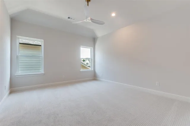 an empty room with a window and a ceiling fan