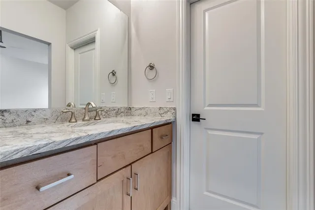 a bathroom with a granite countertop sink a mirror and a bathtub