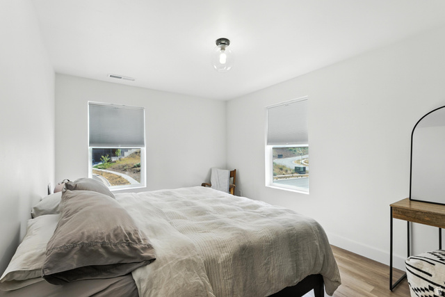 6039 North Westridge Road Heber City, UT 84032 - Photo 12 of 22 Bright interior space featuring two windows with roller shades, light wood-finish flooring, and a contemporary flush-mount ceiling light