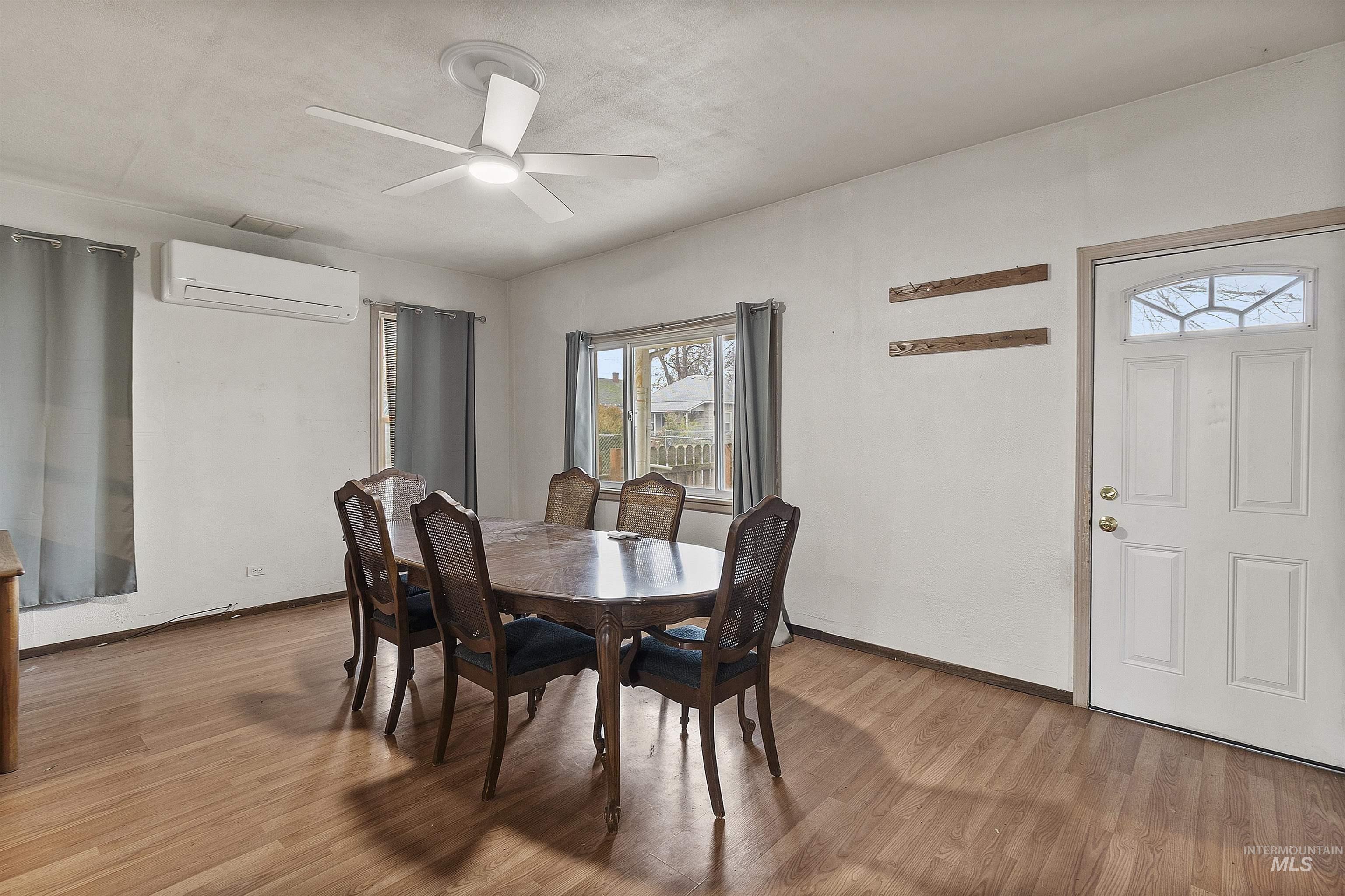 721 9th Street Clarkston, WA 99403 - Photo 20 of 39 Dining room featuring light wood-style flooring, a wall mounted mini split, and a ceiling fan
