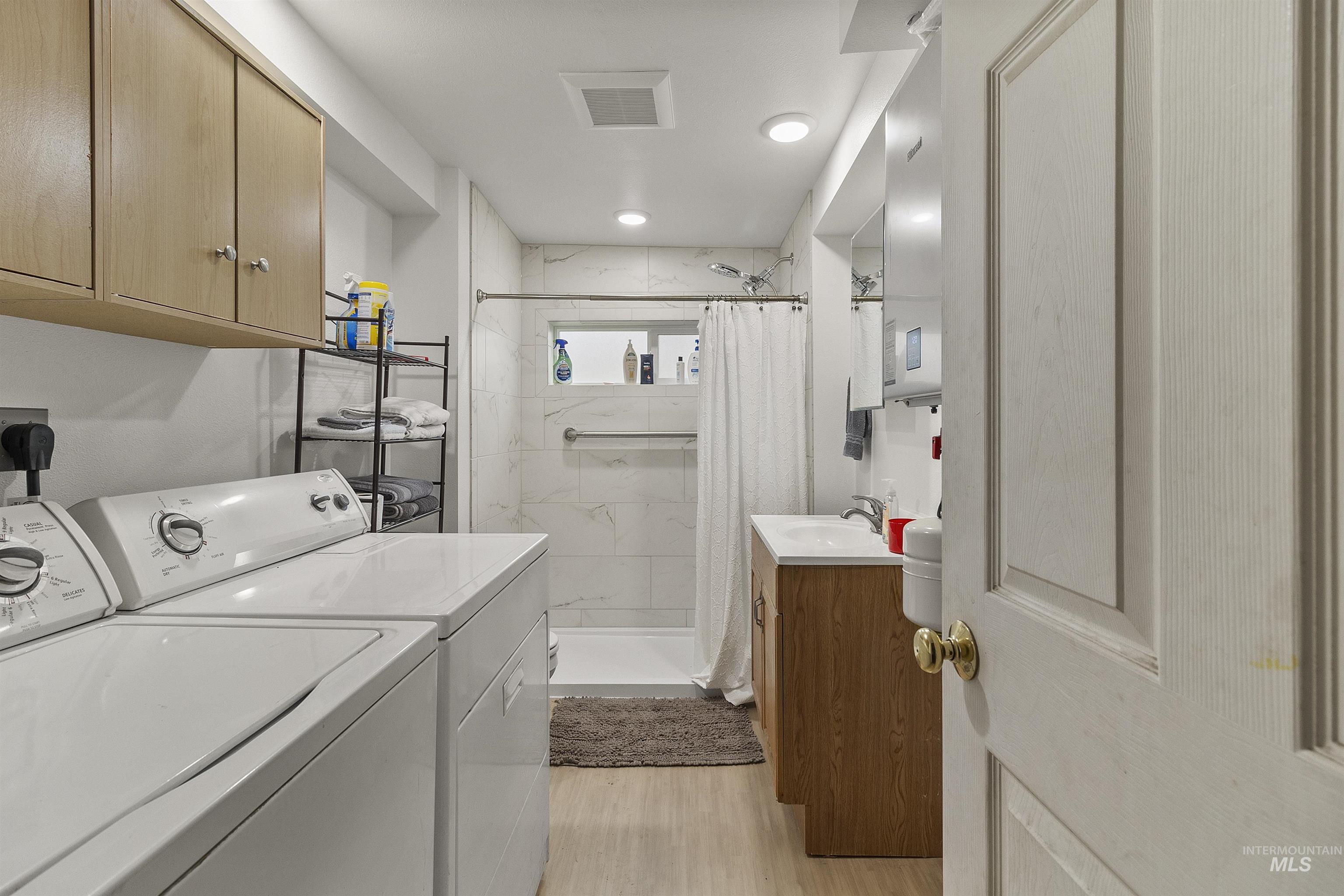 721 9th Street Clarkston, WA 99403 - Photo 21 of 39 Laundry area featuring washer and clothes dryer and light wood-style flooring