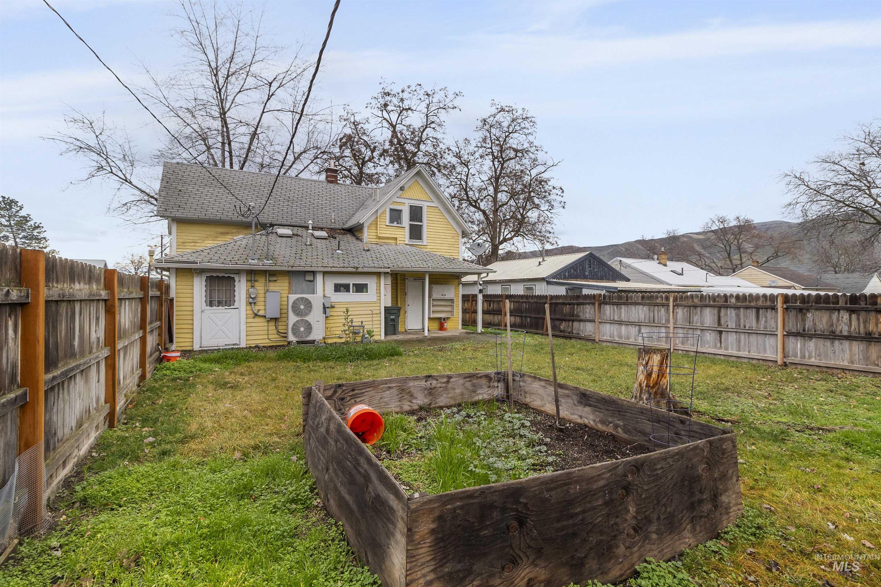 721 9th Street Clarkston, WA 99403 - Photo 7 of 39 Rear view of property featuring a garden, a fenced backyard, and a chimney
