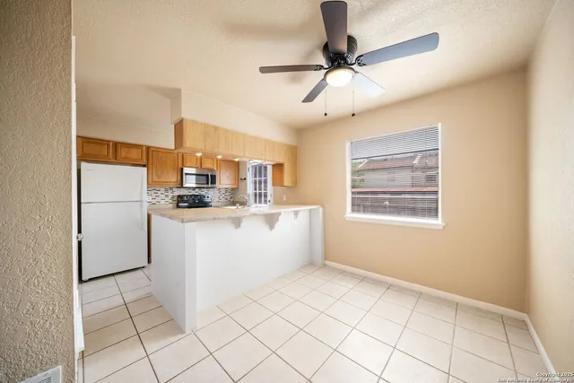 a view of kitchen with furniture and refrigerator
