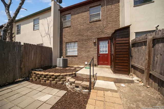 a backyard of a house with barbeque oven and wooden fence