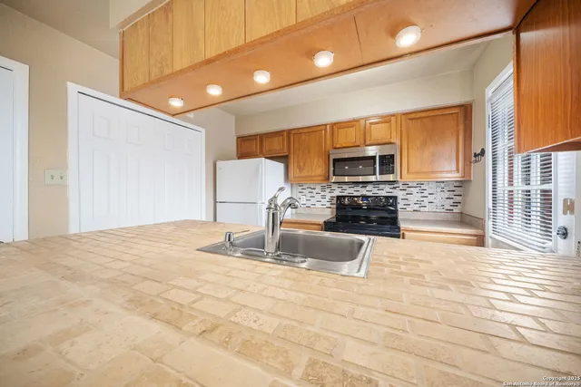 a kitchen with granite countertop a stove a sink and a microwave
