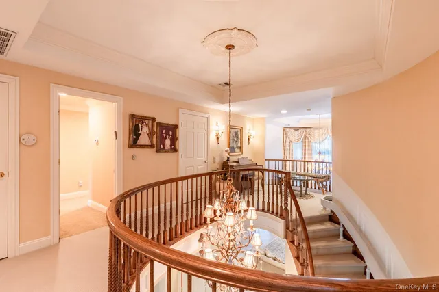 a view of a hallway with a dining table and a chandelier