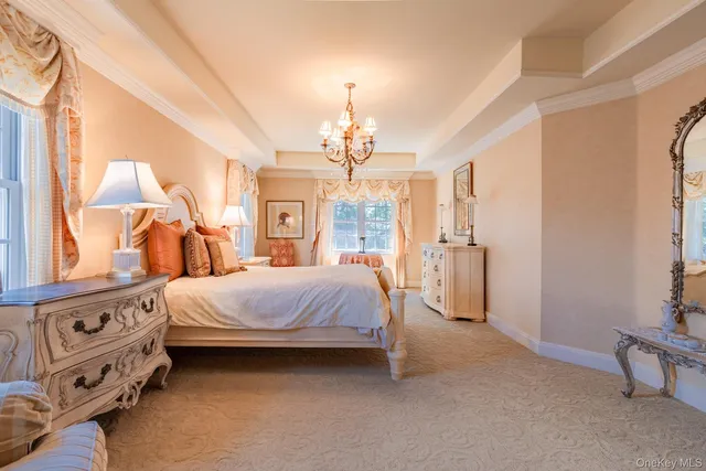 a spacious bedroom with a bed a chandelier and a window