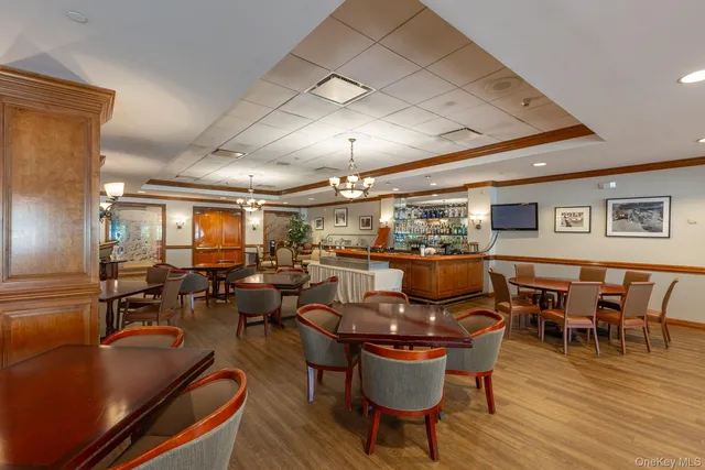 a room with stainless steel appliances dining table and chairs