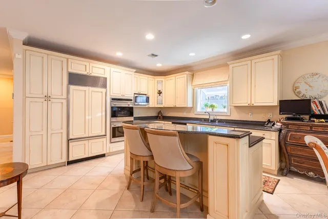 a kitchen with stainless steel appliances granite countertop a stove a sink a refrigerator and a refrigerator