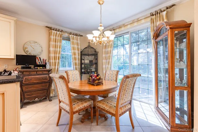a dining room with furniture a chandelier and wooden floor
