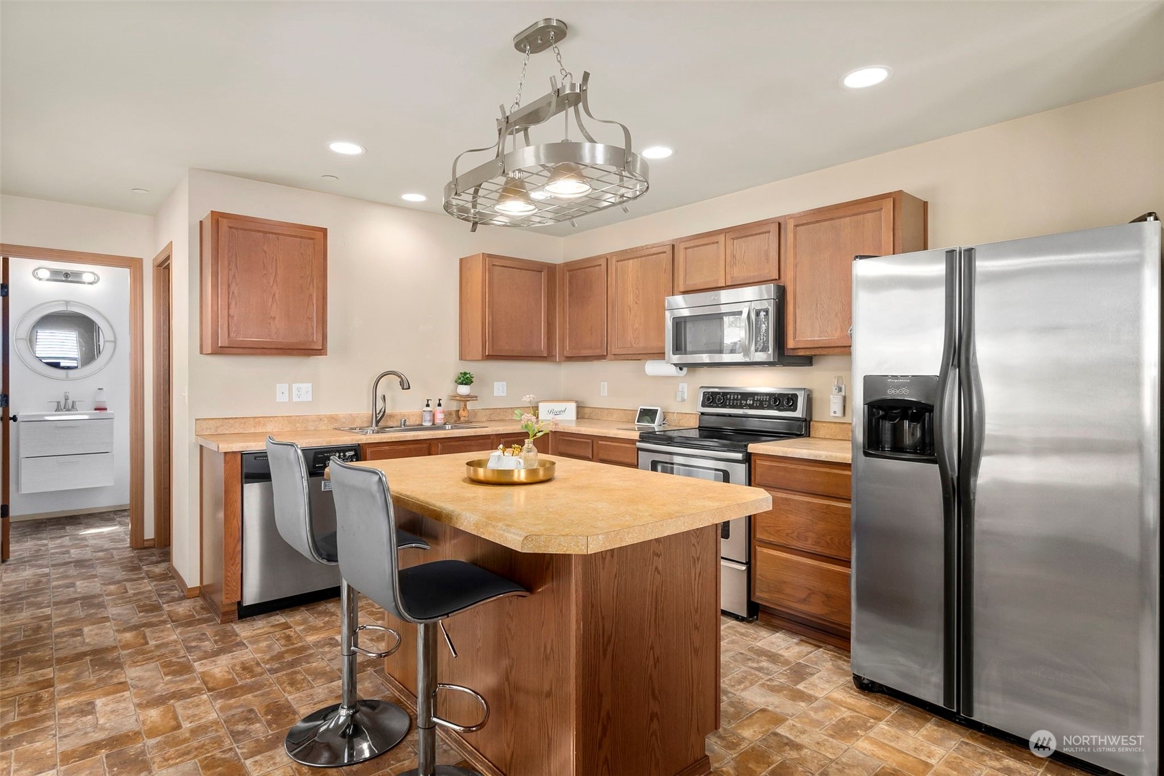 1332 Foreman Road DuPont, WA 98327 - Photo 12 of 32 a kitchen with stainless steel appliances granite countertop a refrigerator a stove a sink and a dining table with wooden floor