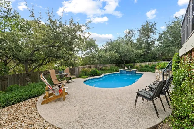 a view of a swimming pool with a yard and furniture