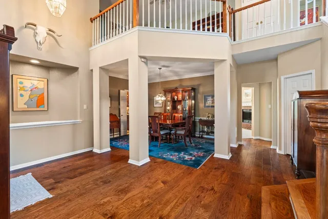 a view of a hallway with wooden floor and a living room