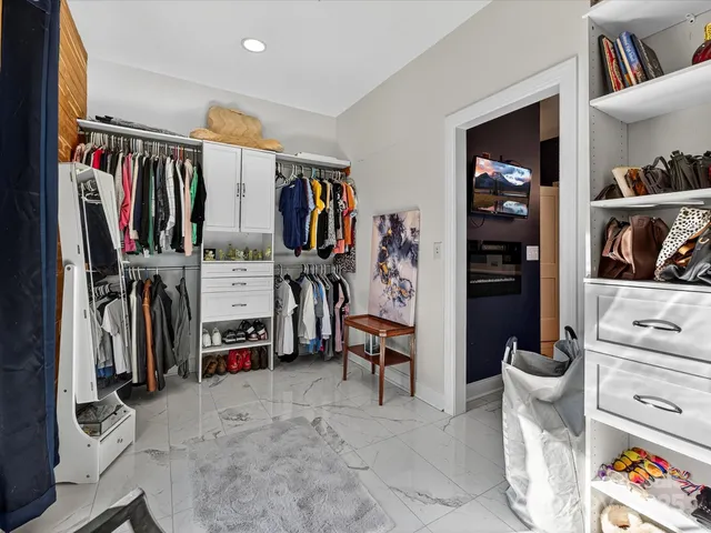 a view of walk in closet with clothes and shoes