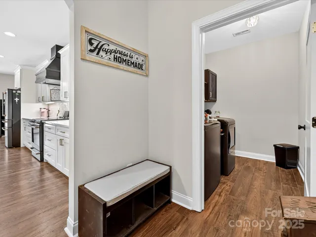 a view of a kitchen with refrigerator and wooden floor