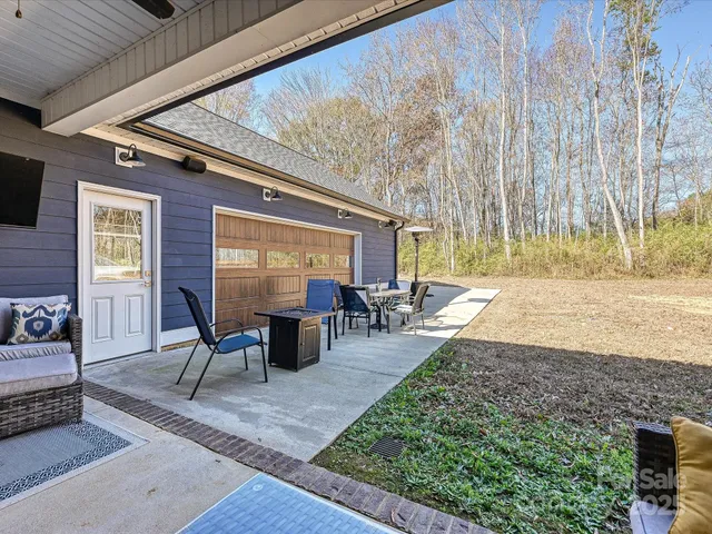 a view of a patio with table and chairs with wooden floor and fence