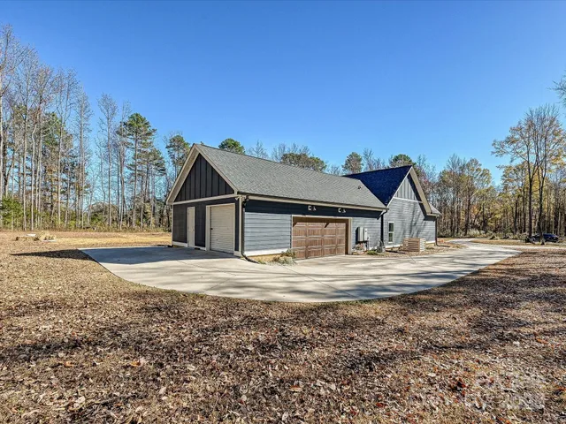 a view of house with outdoor space and trees in the background