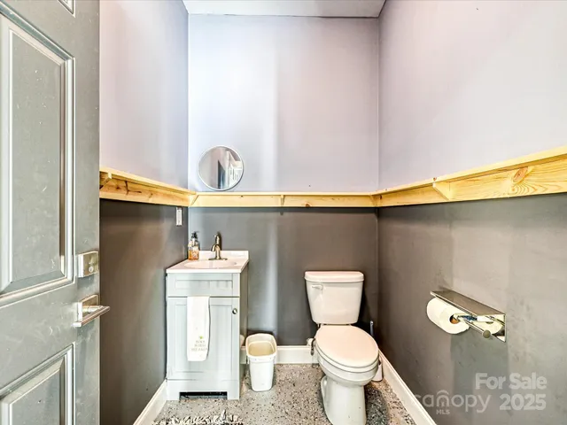 a bathroom with a toilet a sink and a mirror