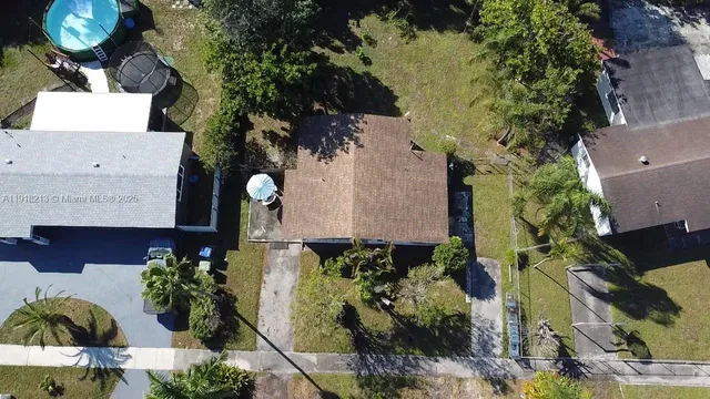 an aerial view of a house with a yard and large trees