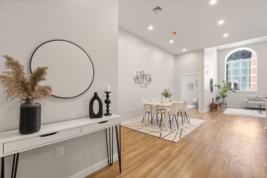 22 Elm Street, Unit 302 Worcester, MA 01608 - Photo 2 of 18 a living room with furniture a mirror and wooden floor
