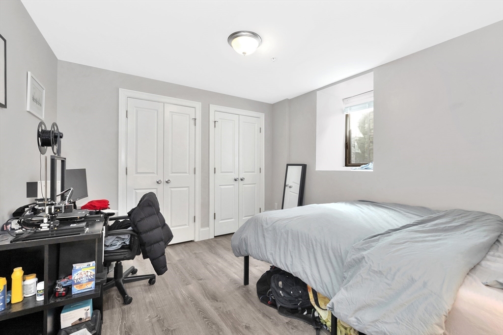 27 Dudley Street Boston, MA 02119 - Photo 32 of 42 a bedroom with a bed and a wooden floor