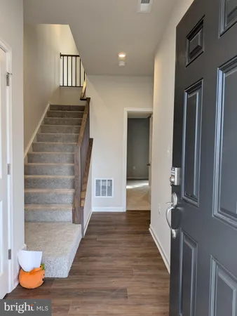 a view of entryway and hall with wooden floor