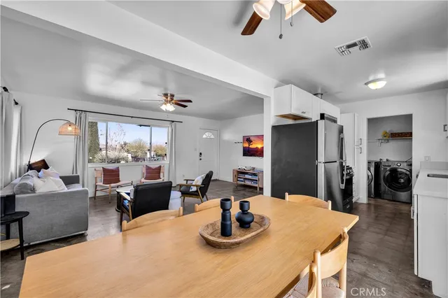 a kitchen with kitchen island a refrigerator dining table and chairs