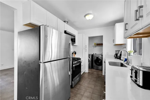 a kitchen with a refrigerator a stove and a sink