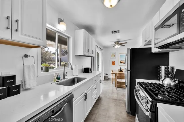 a kitchen with stainless steel appliances a sink stove and refrigerator