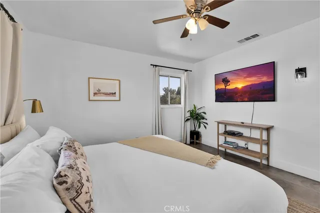 a bedroom with a bed and a flat screen tv