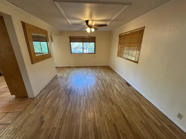 a view of a livingroom with furniture a flat screen tv wooden floor and staircase