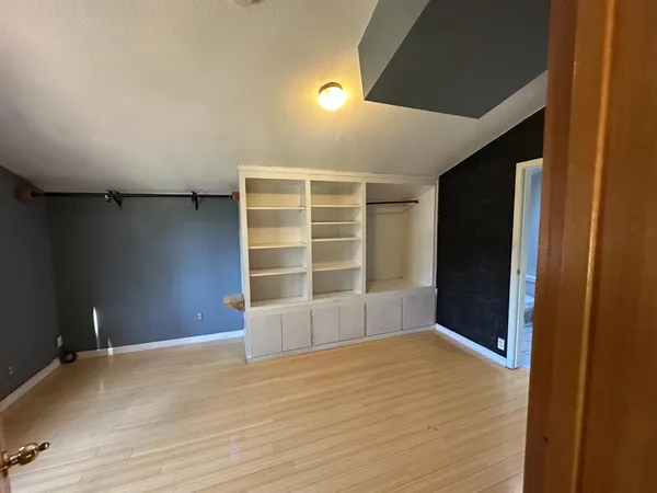 a view of an empty room with closet and entryway