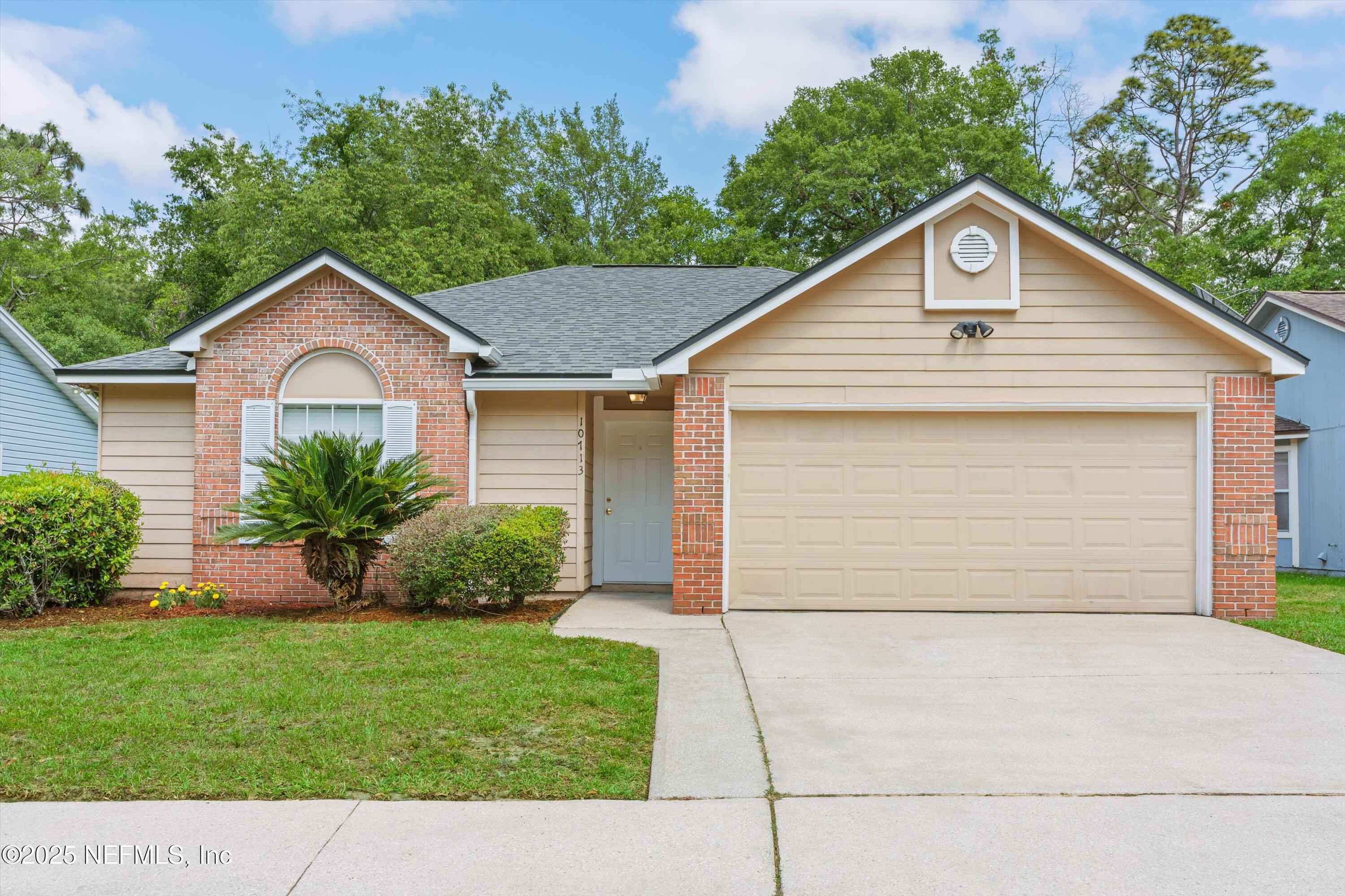 10713 Rutgers Road Jacksonville, FL 32218 - Photo 1 of 26 a front view of a house with a yard and garage