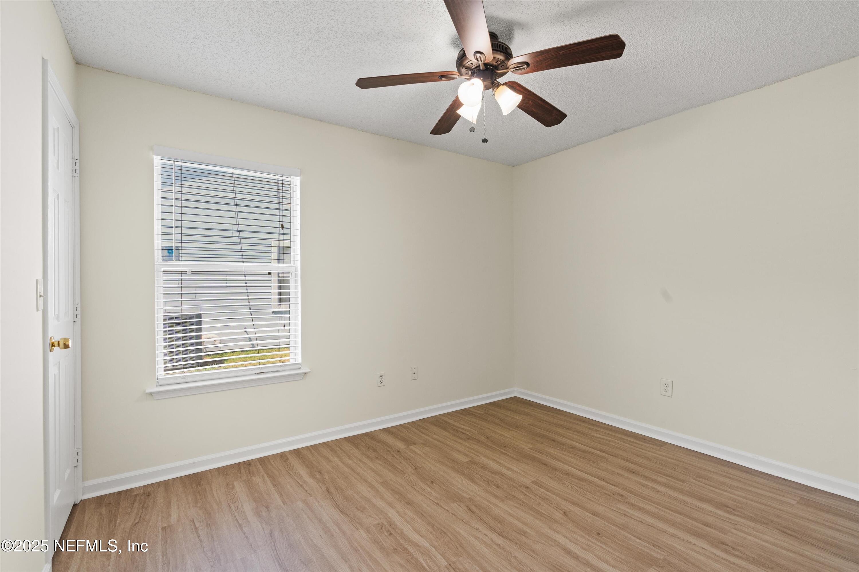 10713 Rutgers Road Jacksonville, FL 32218 - Photo 11 of 26 an empty room with a window and a ceiling fan
