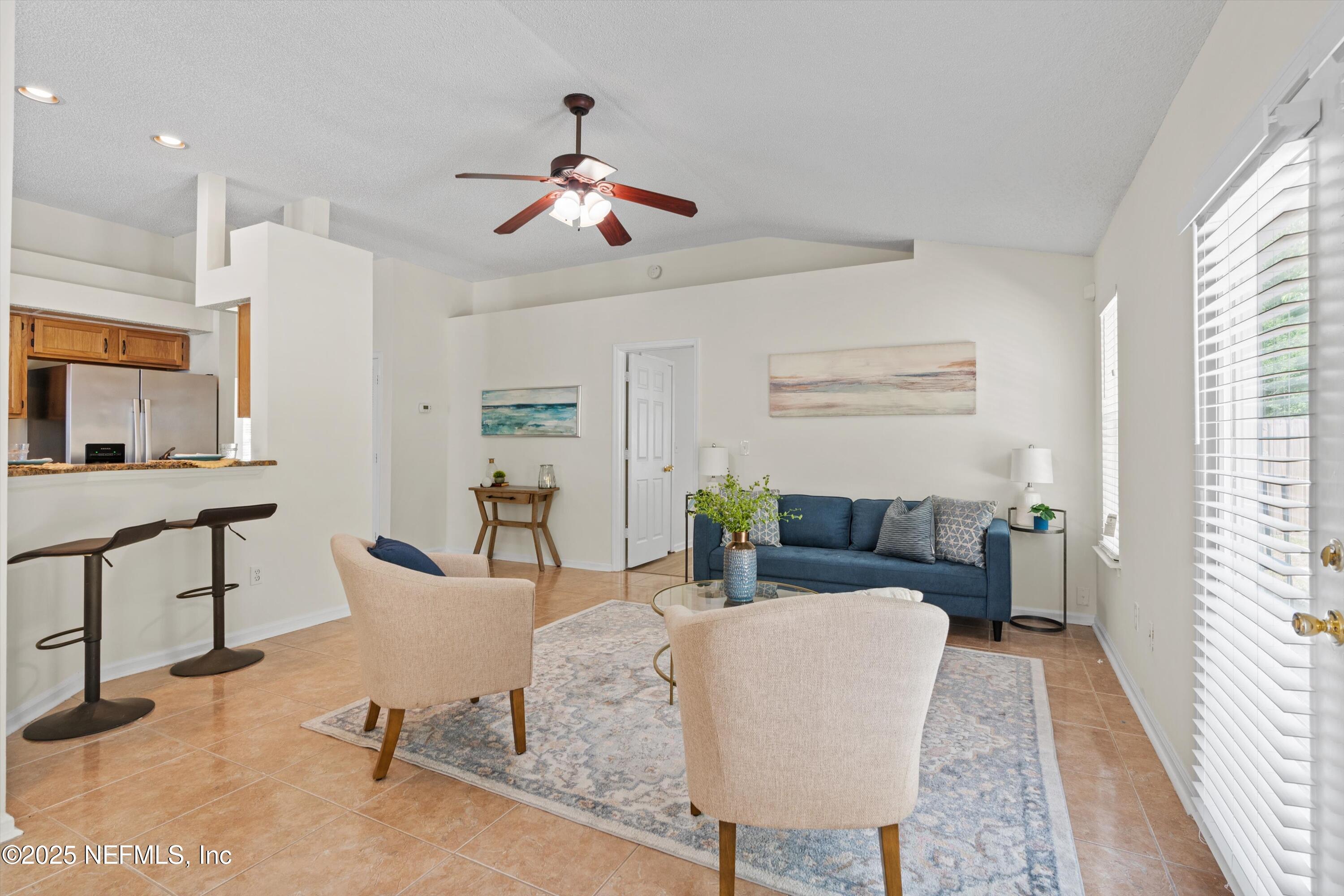 10713 Rutgers Road Jacksonville, FL 32218 - Photo 13 of 26 a living room with furniture and a chandelier