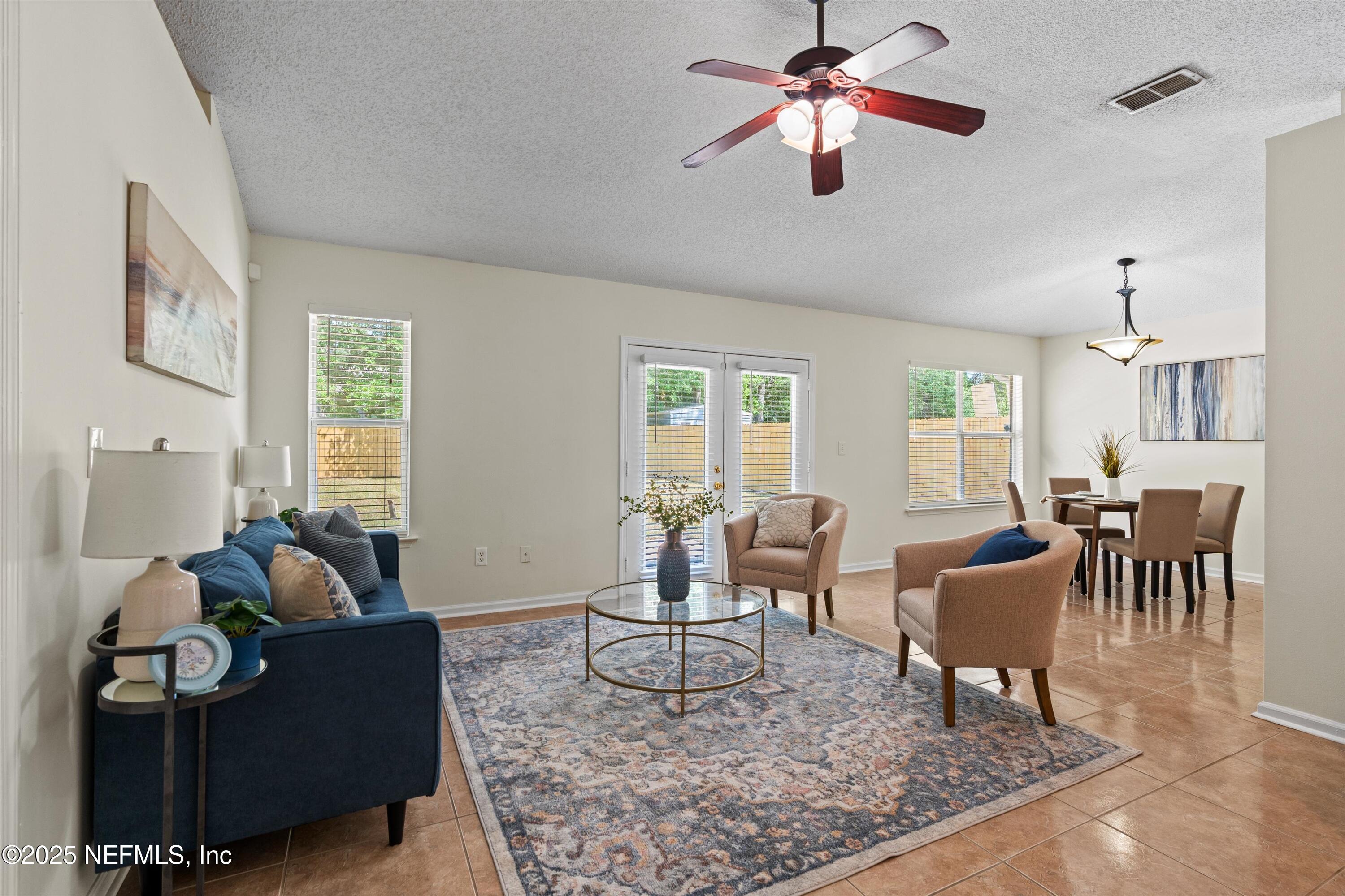 10713 Rutgers Road Jacksonville, FL 32218 - Photo 14 of 26 a living room with furniture and a chandelier
