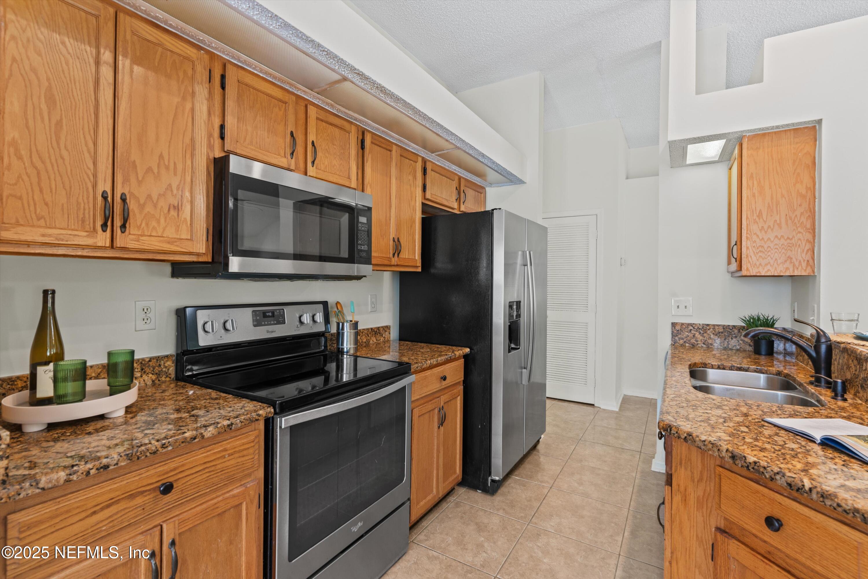 10713 Rutgers Road Jacksonville, FL 32218 - Photo 15 of 26 a kitchen with stainless steel appliances granite countertop a stove microwave refrigerator and sink