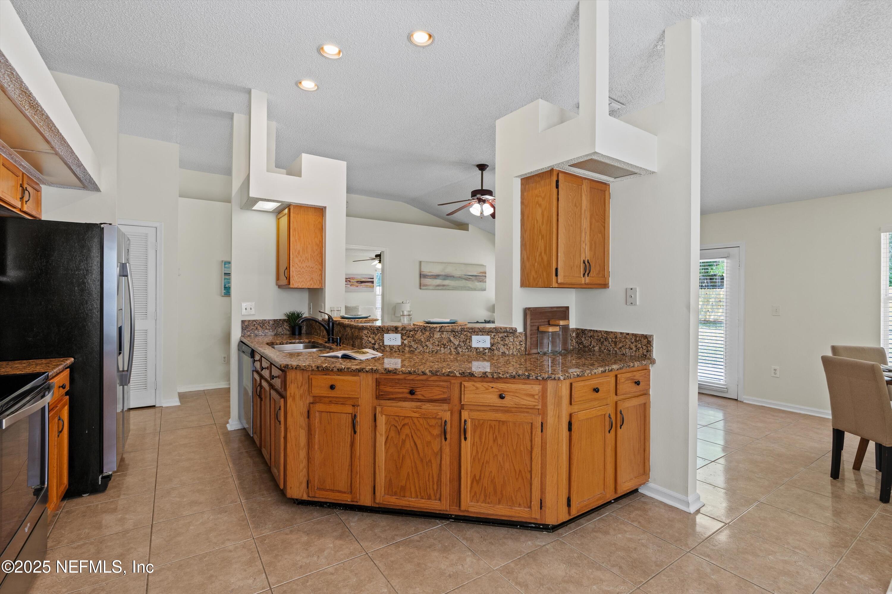 10713 Rutgers Road Jacksonville, FL 32218 - Photo 16 of 26 a kitchen with stainless steel appliances granite countertop a stove a sink and a refrigerator