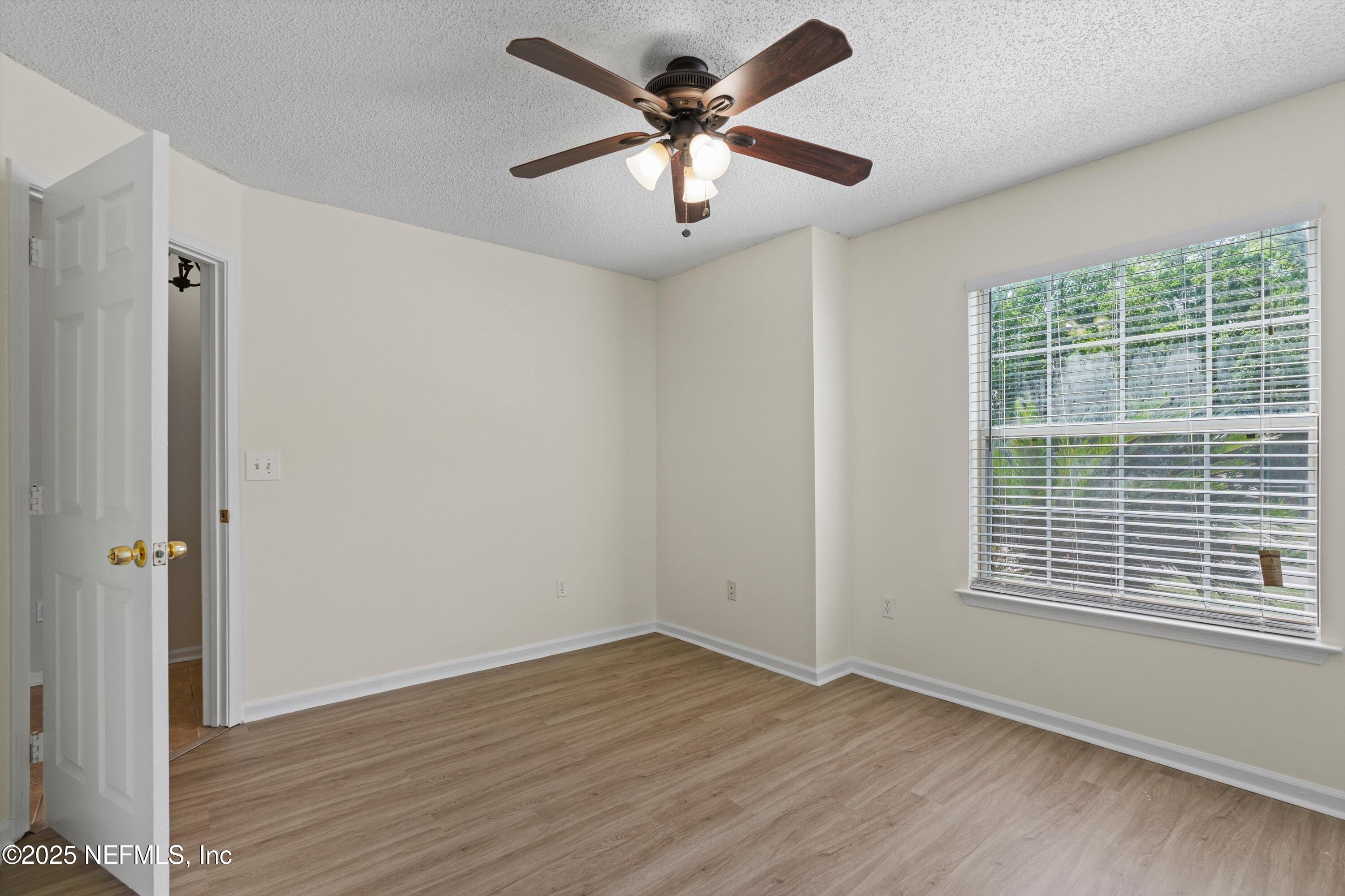 10713 Rutgers Road Jacksonville, FL 32218 - Photo 18 of 26 wooden floor in an empty room with a window
