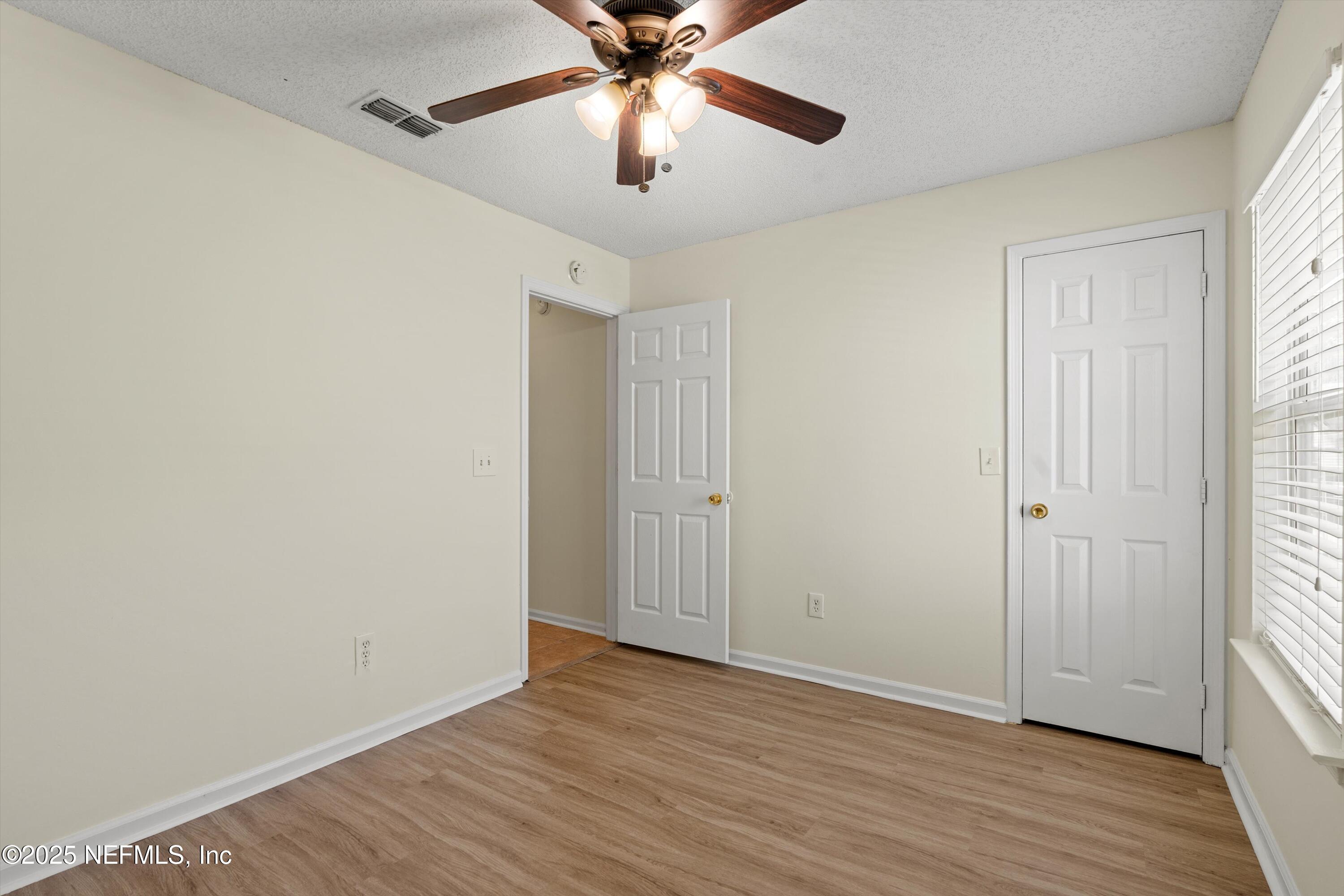 10713 Rutgers Road Jacksonville, FL 32218 - Photo 19 of 26 a view of an empty room with wooden floor and a window