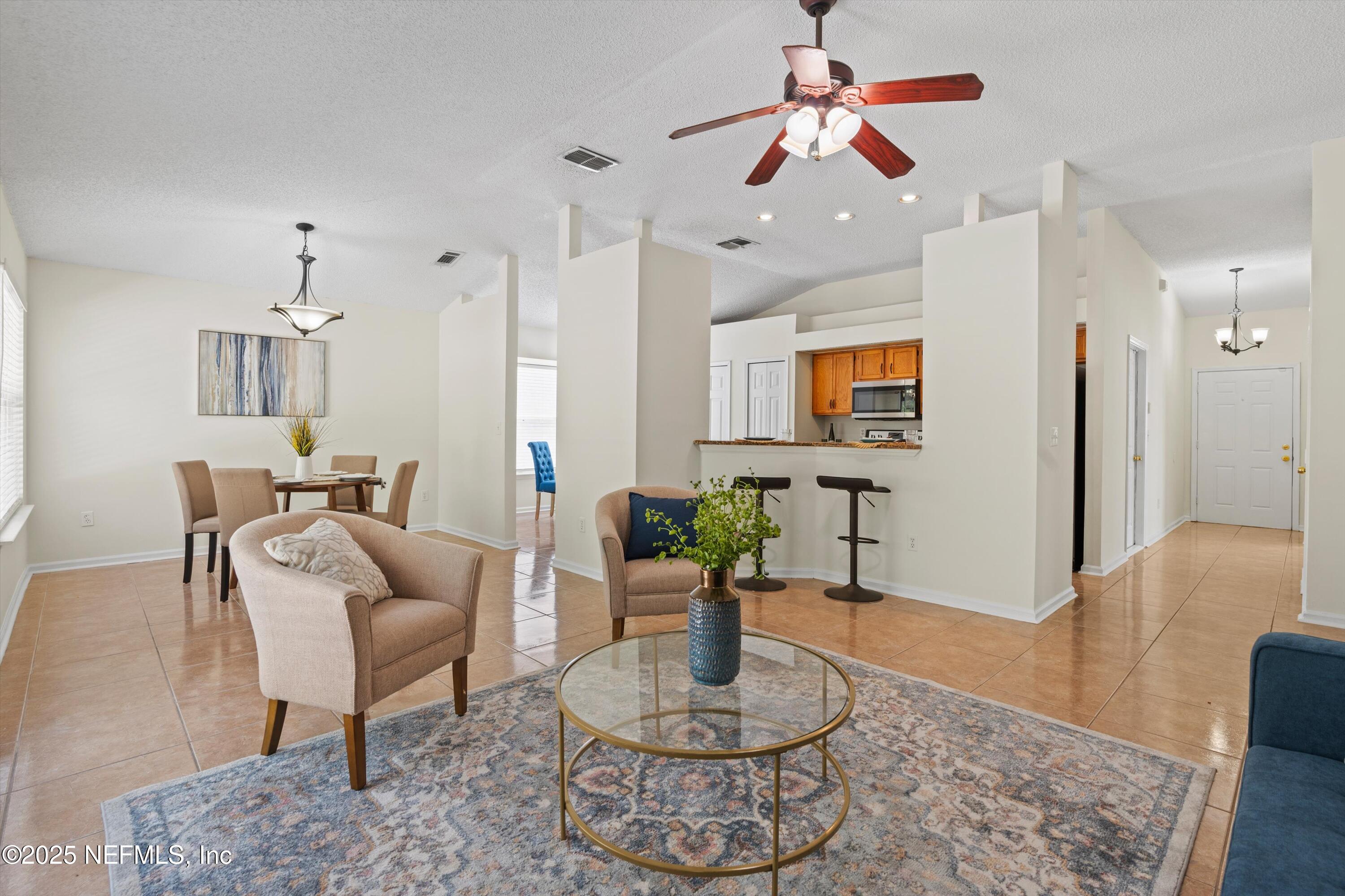 10713 Rutgers Road Jacksonville, FL 32218 - Photo 3 of 26 a living room with furniture and a chandelier