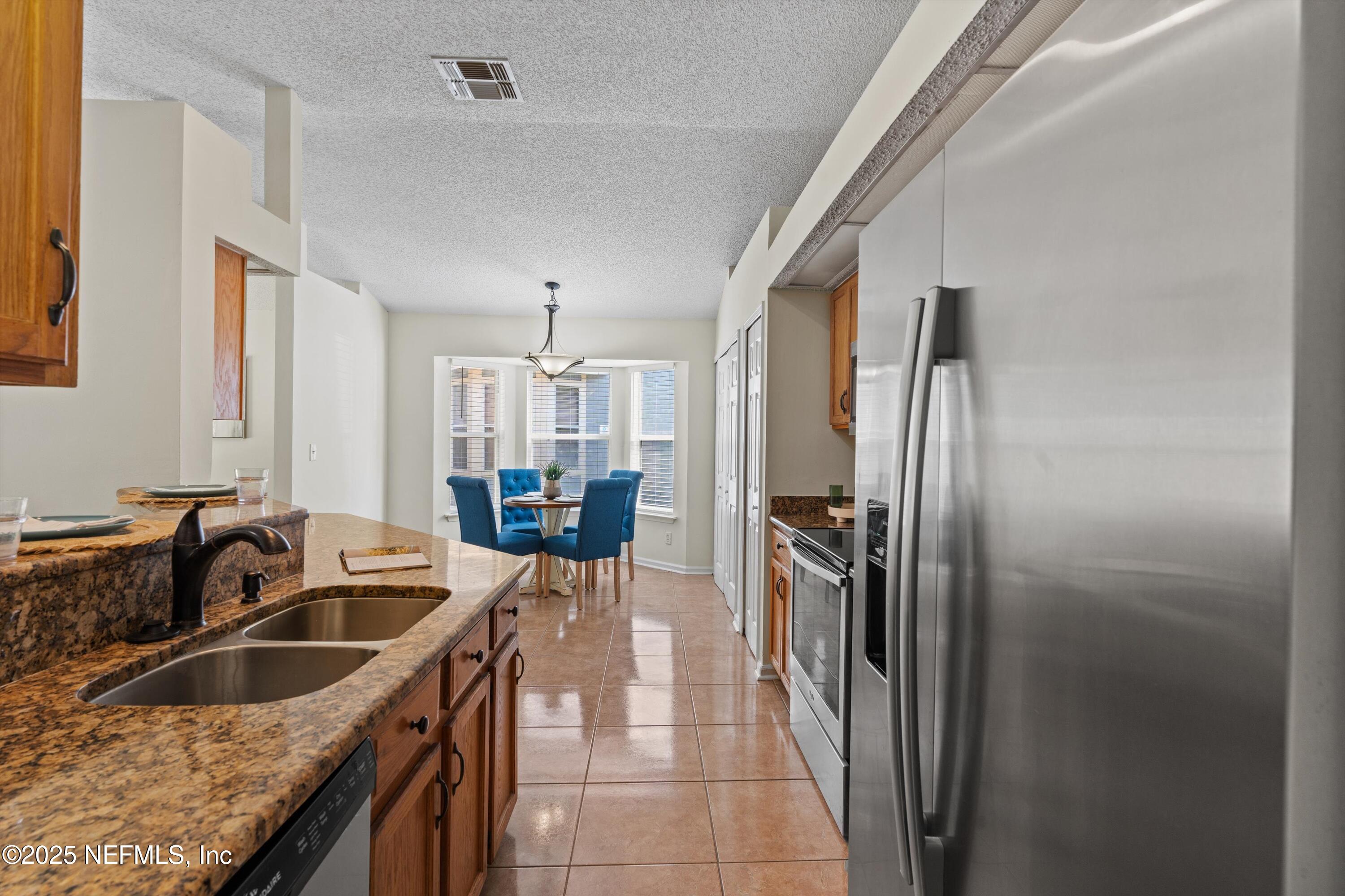 10713 Rutgers Road Jacksonville, FL 32218 - Photo 5 of 26 a kitchen with stainless steel appliances granite countertop a sink stove and refrigerator