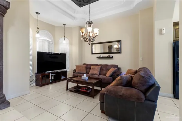 a living room with furniture a flat screen tv and a chandelier