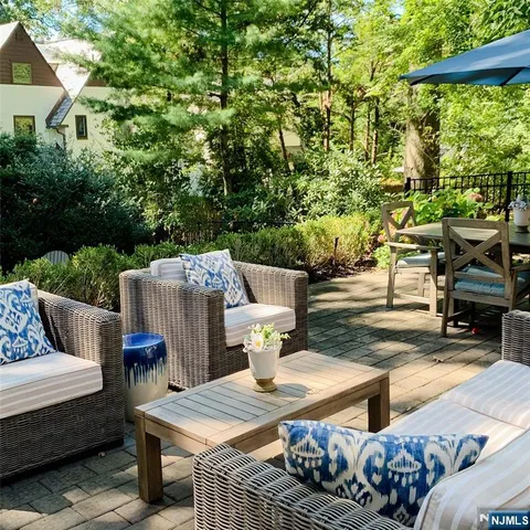 a view of a patio with couches table and chairs and potted plants