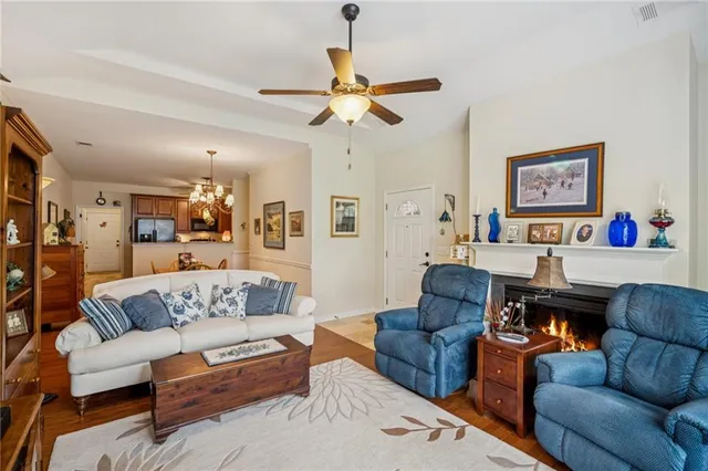 a view of a dining room and livingroom with furniture wooden floor a chandelier
