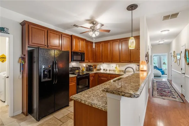 a kitchen with stainless steel appliances granite countertop stove top oven a refrigerator and a sink