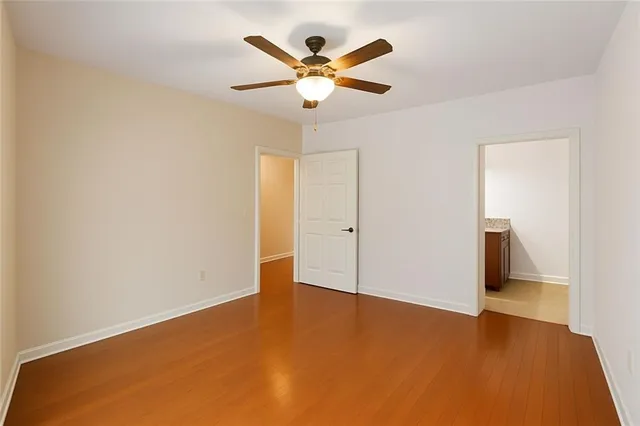 an empty room with closet and ceiling fan