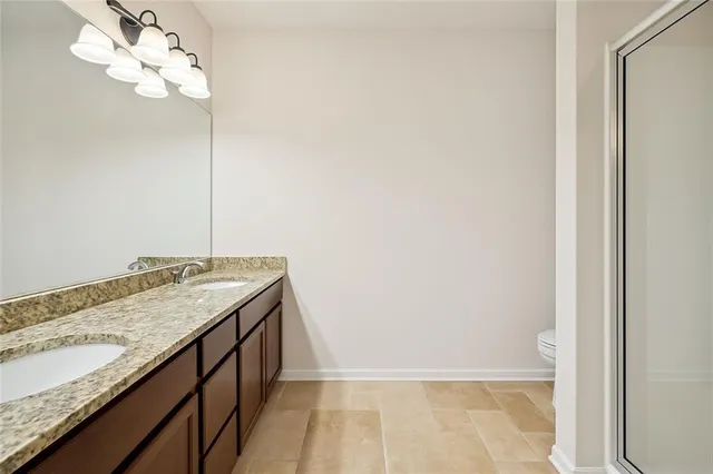 a bathroom with a granite countertop sink and white cabinets