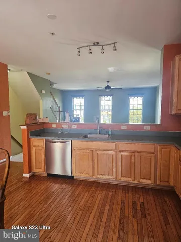 a open kitchen with granite countertop a sink a stove cabinets and wooden floor
