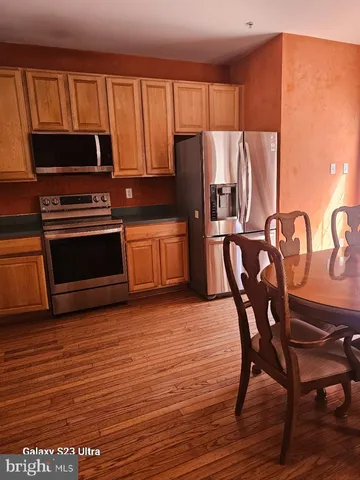 a kitchen with stainless steel appliances a stove a microwave a sink and a refrigerator